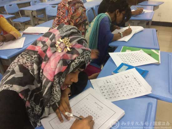 中国侨网学生在认真书写硬笔书法作品