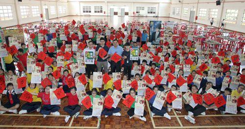 中国侨网学生高举春联及日历与嘉宾合影。(马来西亚《星洲日报》)