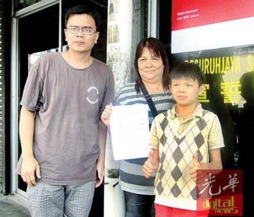 中国侨网萧顺洋在母亲陪同下，前往太平县教育局办理转校手续。（马来西亚《光华日报》）