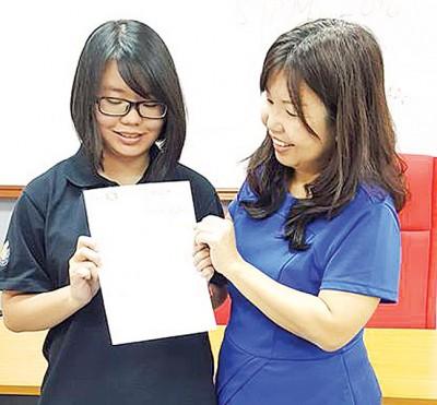 中国侨网全校华文考获A的符洁盈与华文老师纪少芬。(马来西亚《光华日报》)