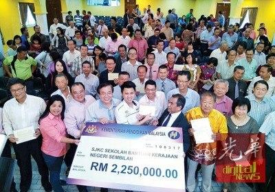 中国侨网张盛闻(前排中)移交225万令吉教育拨款予州内46所华小,与校方代表嘉宾一同合照。(马来西亚《光华日报》)