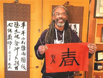 中国侨网图为托尼在展示自己的书法作品。 (屠新时)