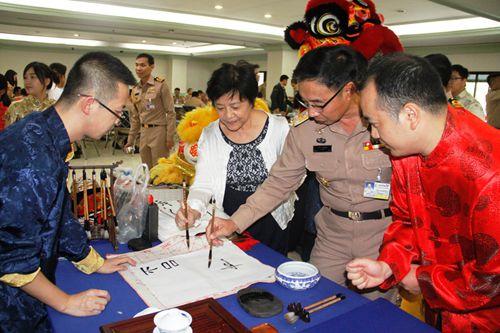 中国侨网泰国海军少将森尼斯饶有兴趣地学写书法