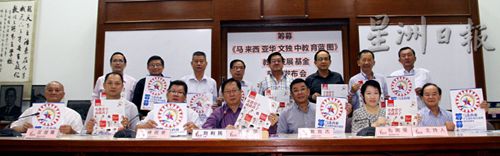 中国侨网刘利民(前排中)携一众董总委员展示“筹募《马来西亚华文独中教育蓝图》教育发展基金”海报和“华文独中教育蓝图(学生篇)”海报,呼吁各界慷慨解囊。(马来西亚《星洲日报》)