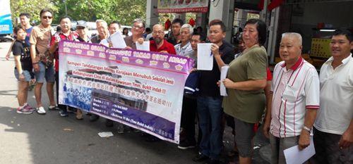 中国侨网叶一德(右七)与居民拉起横幅,表达武吉英达花园居民渴望当地设有一所华小的心声。(马来西亚《星洲日报》)