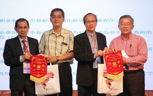 中国侨网2017年马来西亚国民型华文中学校长教育研讨会筹委会主席黄奕仁(左一)和马来西亚国民型华文中学校长理事会主席陈德祥(右二)颁发锦旗予廖国华(左二)和周世扬。(马来西亚《星洲日报》)