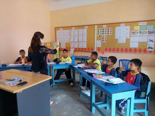 中国侨网北根港口育华华小老师教导学生。（马来西亚《星洲日报》）