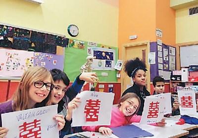 中国侨网西班牙一所小学里的学生举起了自己的剪纸作品