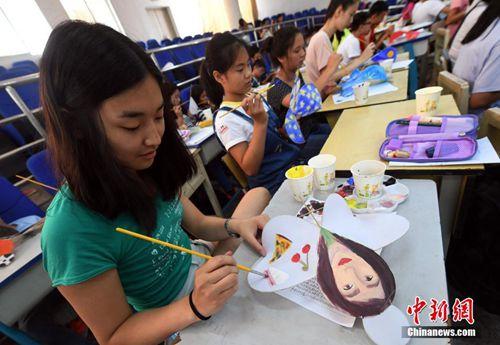 中国侨网7月26日，学生们在滇派硬翅风筝上绘制自己喜欢的图案。 中新社记者 李进红 摄