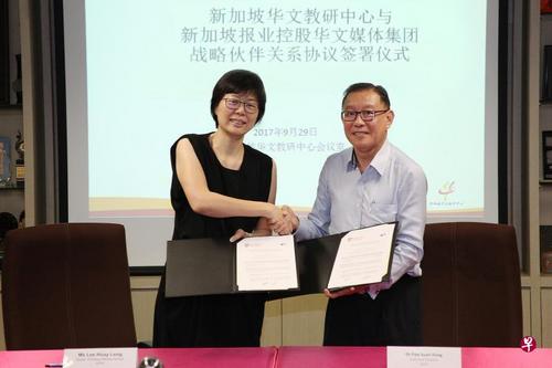 中国侨网新加坡报业控股华文媒体集团主管李慧玲（左）同新加坡华文教研中心院长符传丰博士签署战略伙伴关系协议。（新加坡《联合早报》）