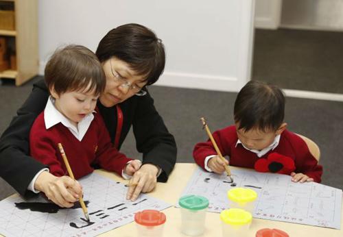 中国侨网位于伦敦市区的肯辛顿·韦德小学今年9月刚开学，就以“浸入式”汉语教学特色引起英国媒体和家长广泛关注。该校是欧洲首家中英双语小学。图为学生们学写毛笔字。（参考消息网 韩岩 摄）