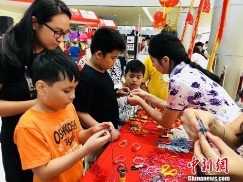 中国侨网图为菲律宾孩童学习编制中国结。　樊蓉　摄
