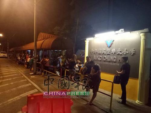 中国侨网凌晨排队为孩子报名,家长牺牲睡眠,在校门外排长龙。(马来西亚《中国报》)