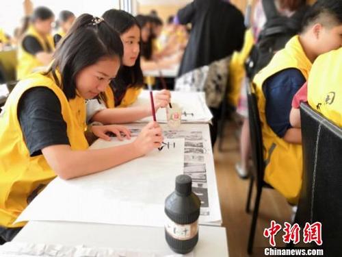 中国侨网4月10日,泰国华裔青少年在江西鹰潭龙虎山华泉小村传习中国书法、写中国字。 金心 摄