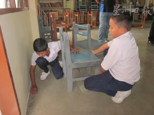 中国侨网小学生翻桌倒椅，要寻找小昆虫的踪迹。（马来西亚《星洲日报》）