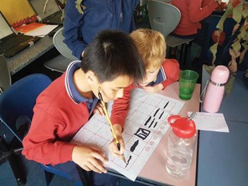 中国侨网Rotorua男子高中的学生练习中国书法。（新西兰天维网/维多利亚大学惠灵顿孔子学院）