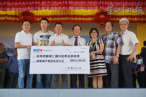 中国侨网善心人士代表移交模拟支票给峇株巴辖五校董事会。左四为陈大锦。（马来西亚《星洲日报》）