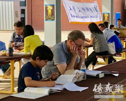 中国侨网南加州中文学校联合会秋季学术比赛上孩子们等待老师派发试卷。（美国《侨报》/翁羽 摄）