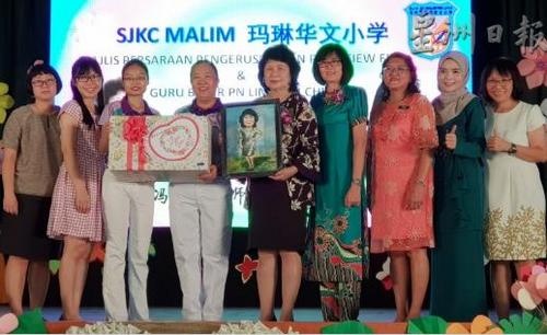 中国侨网教师福利组赠送礼物及Q版画像给冯秋苹(中)。(马来西亚《星洲日报》)