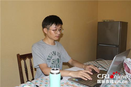 中国侨网陈欢在客厅的餐桌上工作。