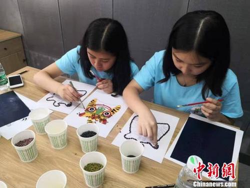 中国侨网  来自澳大利亚、意大利、美国等7个国家的120余名海外华裔青少年体验五谷作画。太原市侨联供图