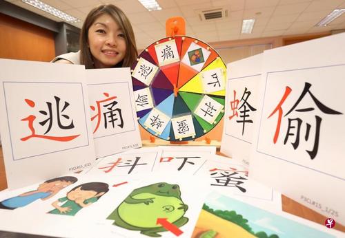 中国侨网圣婴女子小学华文教师谢秀彬展示字卡教具。(新加坡《联合早报》/何炳耀 摄)