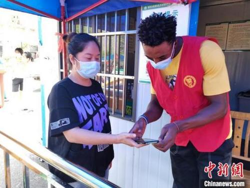 中国侨网王大卫当疫情防控志愿者负责查验健康码。受访者供图