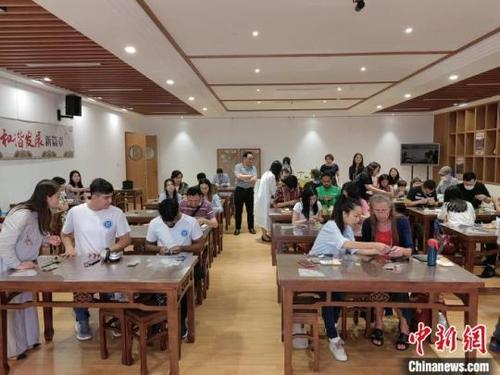 中国侨网数十名国际友人齐聚一堂，共同学习香囊制作工艺。刘俊聪摄