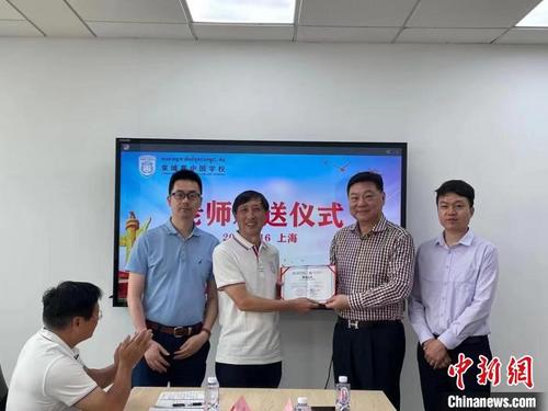 中国侨网高华(右二)为执行校长陈自元(左二)颁发聘用证书。 柬埔寨中国学校供图