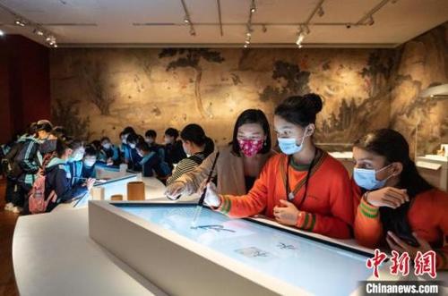 中国侨网立法会议员林琳教少数族裔学生写中国毛笔书法。 主办方 摄