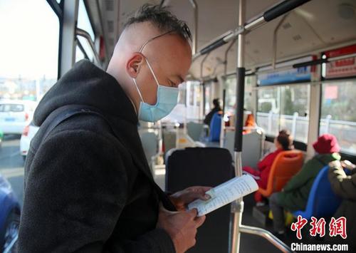 中国侨网图为叶根芽在公交车上学中文。 孙睿姣 摄