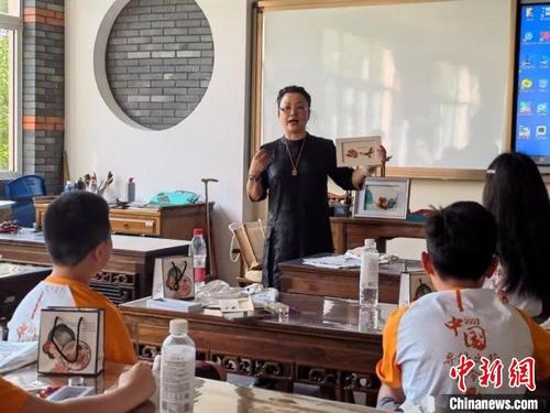 珊丽娜向华裔少年介绍盘扣艺术。　上海市侨联供图