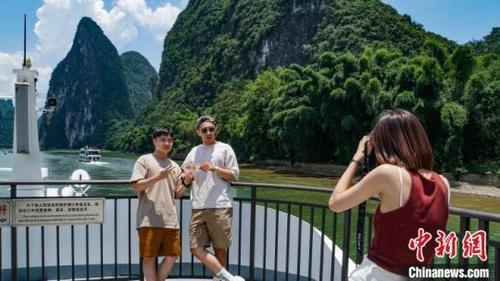 台湾青年在二十元人民币背景图“黄布倒影”处打卡拍照。蒋丰慧摄