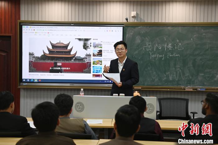 中国侨网3月26日,湖南中医药大学的国学课堂吸引众多留学生参与。课堂上,留学生在老师指导下学习《岳阳楼记》,并将其译为英文接力诵读,借此增进对中国文化的理解 。图为老师向留学生们介绍岳阳楼。中新社记者 杨华峰 摄