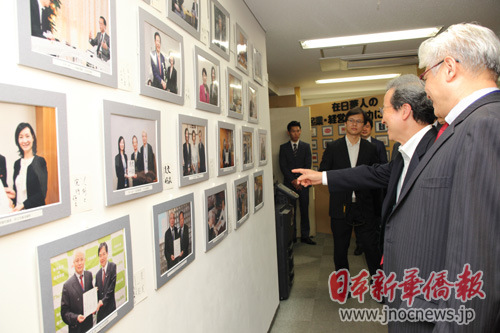 中国侨网蒋丰(右一)向程永华大使(右二)介绍报刊发展情况(日本新华侨报网)