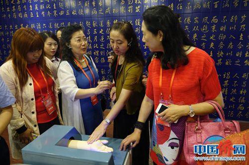 中国侨网50余家海外华文媒体代表参观天津滨海高新区。大家在模拟脉搏仪器上“把脉”。冉文娟 摄