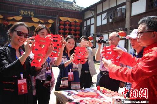 中国侨网图为海外华文媒体高层在走马古镇体验剪纸艺术。　高吕艳杏　摄