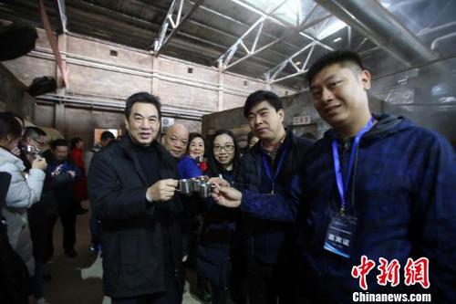 中国侨网27日，海外华文媒体代表在五粮液酿酒车间品尝原浆酒。 王磊　摄