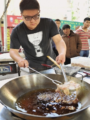 郭方正在炸鸡,动作相当娴熟老练,一点不像新手。