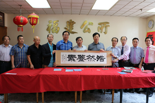 福建省海外交流协会一行将带来的礼物赠送给福建公所。(美国《侨报》/苏夏竹