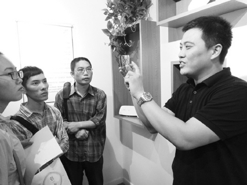 ▲8月17日,颜景川(右一)正在向参观者介绍公司激光打印产品。（《大众日报》/杨淑栋