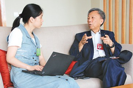 图为方君学(右)接受记者采访。