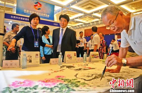 天津市委常委、统战部部长王宏江（左二）参观展会。