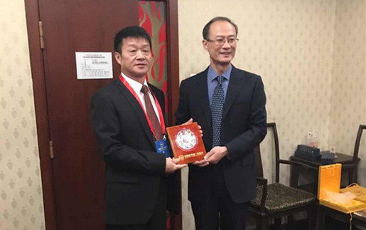 中国和平统一促进会副秘书长孙凌燕（左）向陈庆平赠送纪念品。