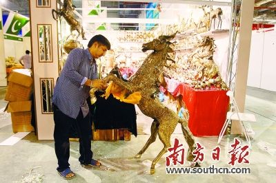 26日,海丝博览会展馆内,外国参展商正在加紧布置展位。图为缅甸参展商正在擦拭他们的展品。