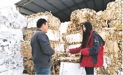 中国侨网这是桂博文的废品回收站，她（右）正与工作人员交谈工作事宜。