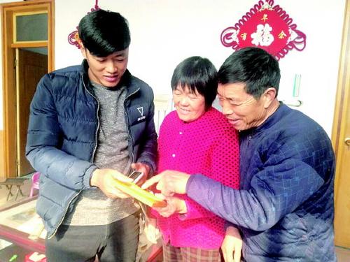 中国侨网袁加涛和父母翻看着以往拍的全家福。