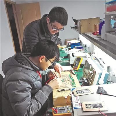 中国侨网冯维一（后）在实验室指导技术人员研发。 （张燕 摄）