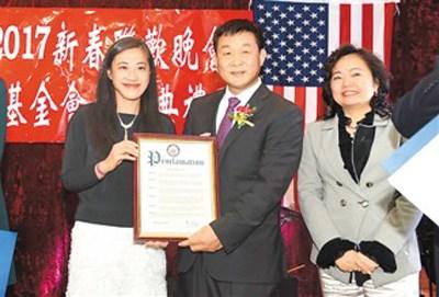 中国侨网图为美国国会议员孟昭文代表黄敏怡(左一)向张富印(中)颁发美国国会褒奖状。