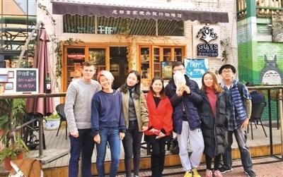 中国侨网唐雨冬（右三）在自己创立的首家旅行主题咖啡馆前合影。